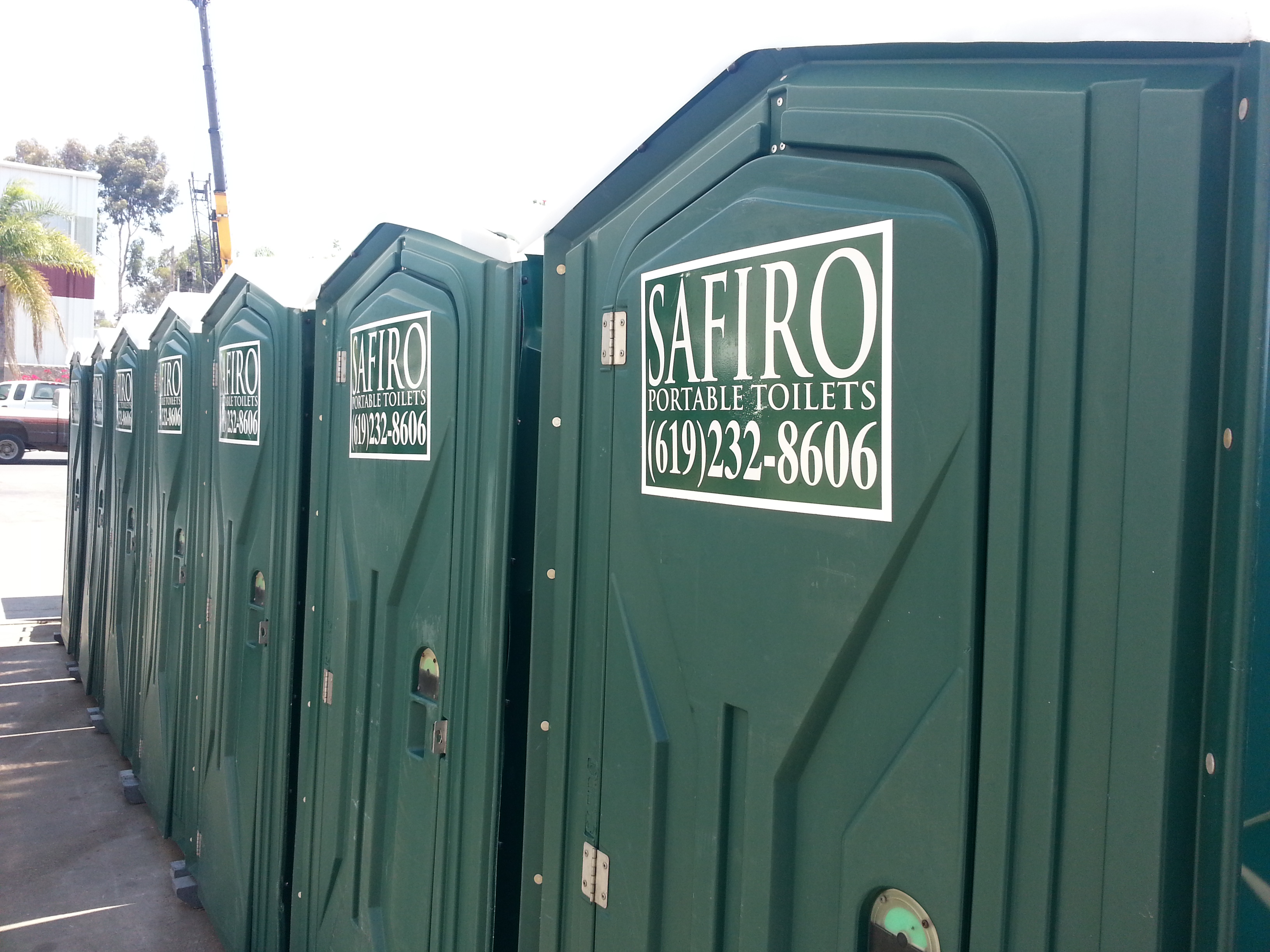 Safiro's portable toilet rentals lined up at an outdoor San Diego event